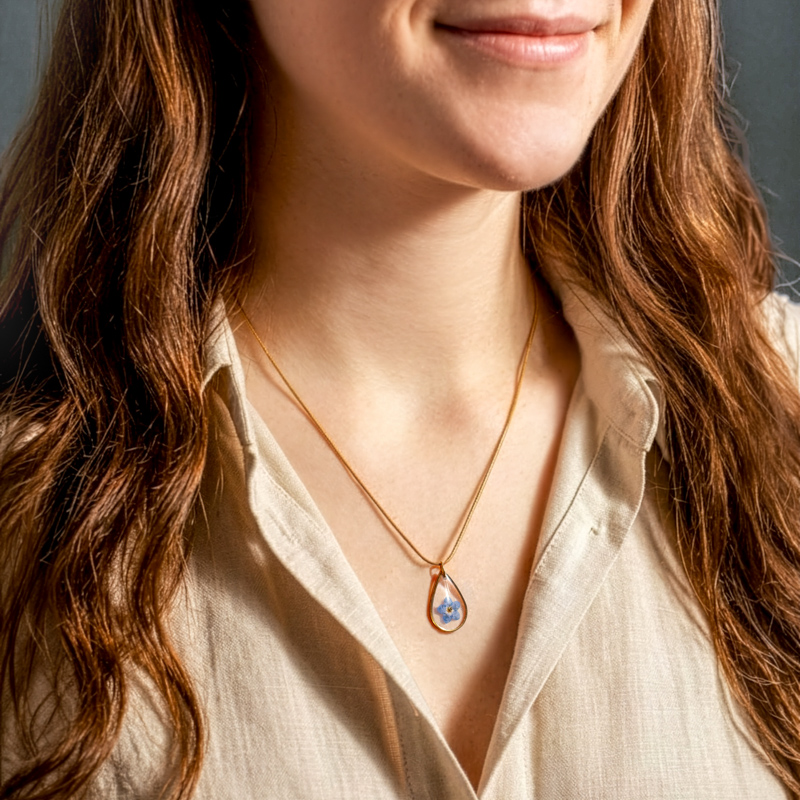 Vrouw draagt ketting met vergeet-me-niet hanger