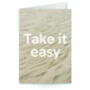 wenskaart met tekst Take it easy met zand op de achtergrond