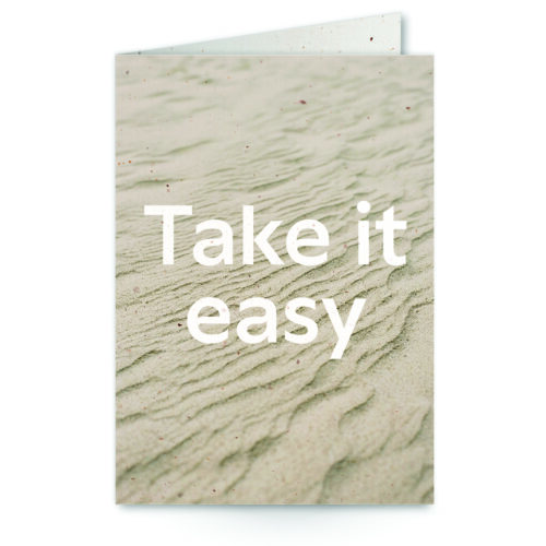 wenskaart met tekst Take it easy met zand op de achtergrond